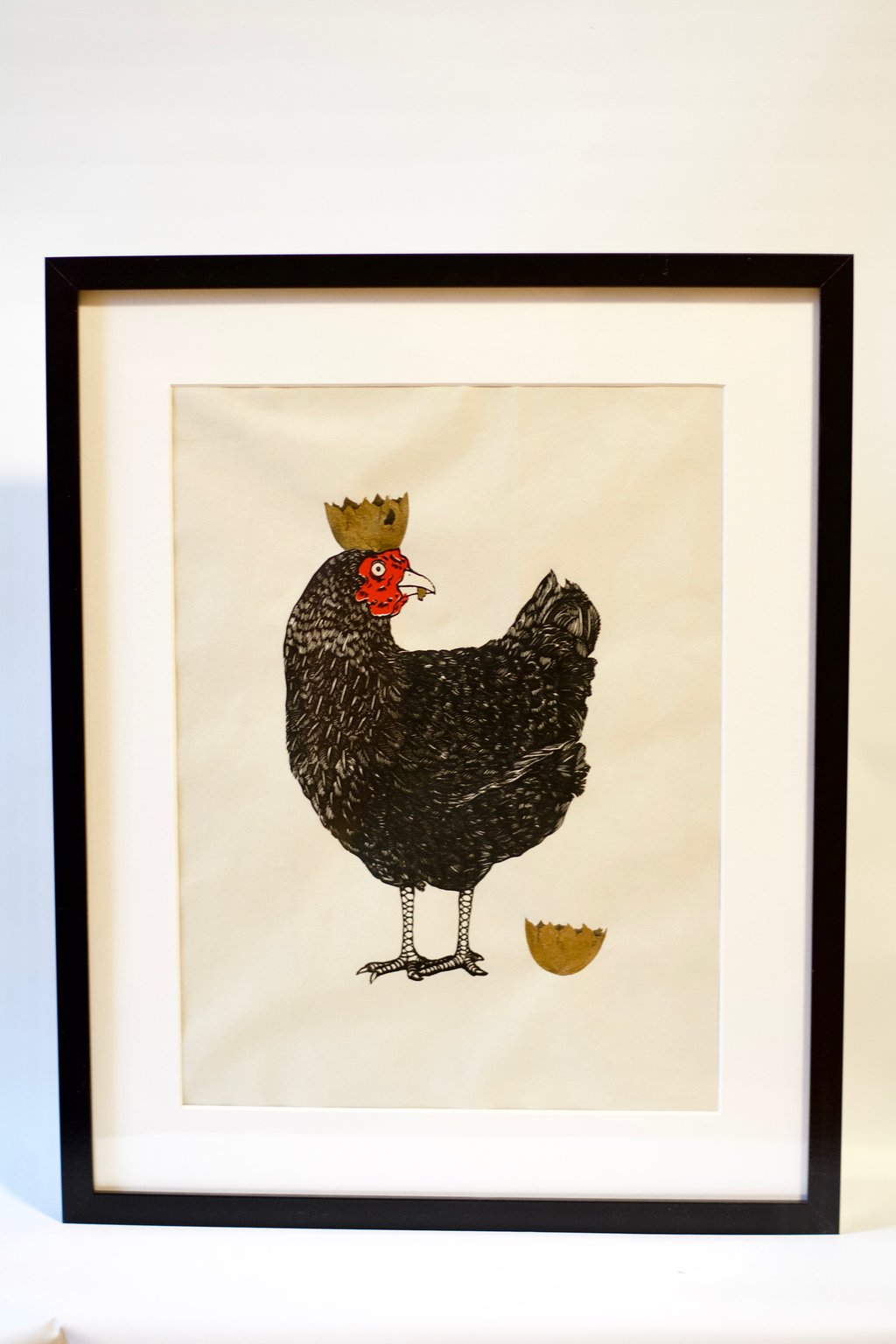 A photo of a drawing of a chicken with an eggshell on its head like a crown